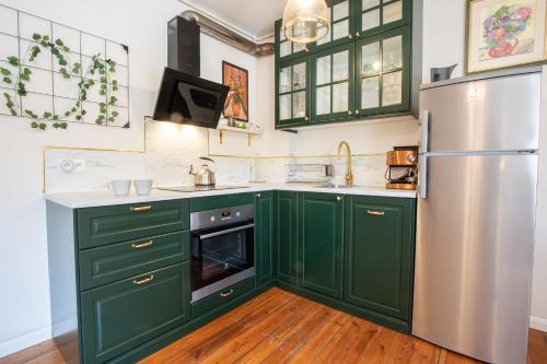 a kitchen with green cabinets and a stainless steel refrigerator at Mrongowiusza 3 in Olsztynek