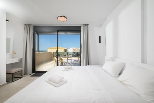 a bedroom with a large white bed and a balcony at Petrus Luxury Villas in Old Hersonissos - 3 Bedrooms & 3 Bathrooms in Hersonissos