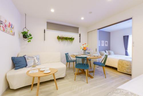 a living room with a couch and a bed and a table at Serene Stay Nagoya JADE 101 in Nagoya