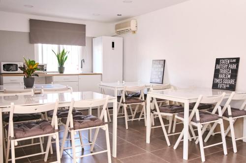 a dining room with white tables and chairs at V Pension & Suites in Burriana
