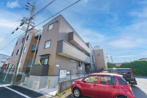 a red car parked in front of a building at Serene Stay Nagoya JADE 101 in Nagoya