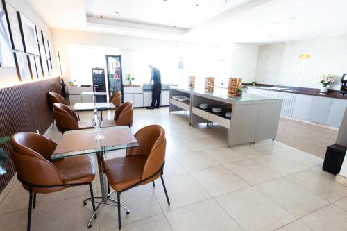 a room with chairs and a table and a kitchen at Sofisticado Flat em Brasília-BR in Brasilia