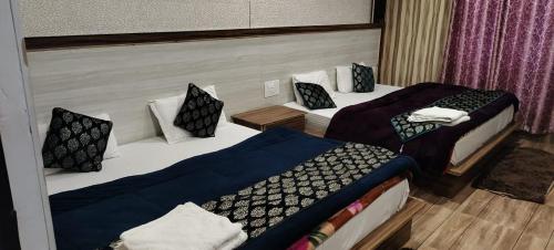 a room with two beds in a room at Laxmi Divine Badrinath in Badrīnāth