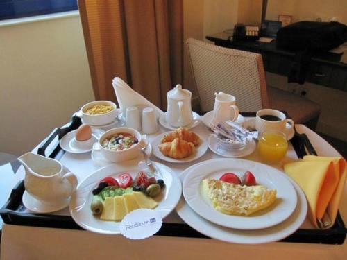 a breakfast tray with breakfast foods on a table at Primland Hotel Buyala in Buloba