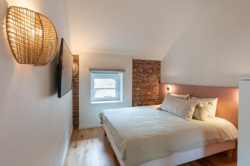 a bedroom with a bed and a brick wall at Ardn-bnb Bike n Bed in La Roche-en-Ardenne