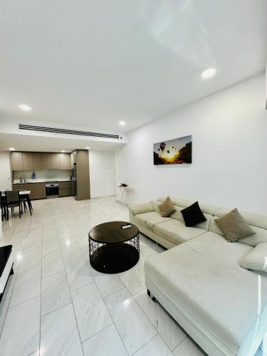 a white living room with a couch and a table at Eaton Residences By Classic in Kuala Lumpur