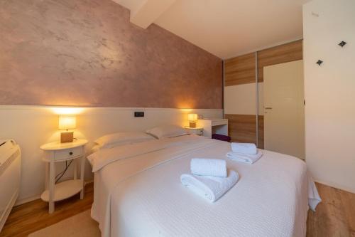 a bedroom with a white bed with two towels on it at Villa Adria in Kotor