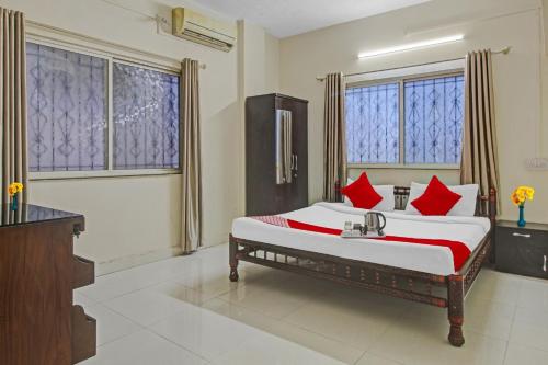 a bedroom with a large bed with red pillows at Hotel O Star in Kharadi