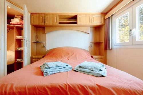 - 2 serviettes assises au-dessus d'un lit dans une chambre dans l'établissement Mobile Home - 700m de la plage, à Saint-Georges-de-la-Rivière