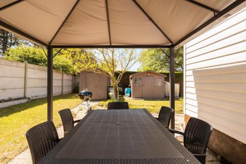 - une table et des chaises sous un parasol dans la cour dans l'établissement Mobile Home - 700m de la plage, à Saint-Georges-de-la-Rivière