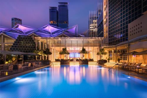 a large swimming pool in a city at night at Conrad Singapore Marina Bay in Singapore