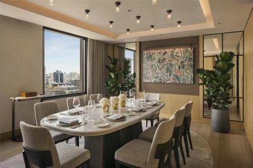 a dining room with a table and chairs and a large window at Conrad Singapore Marina Bay in Singapore