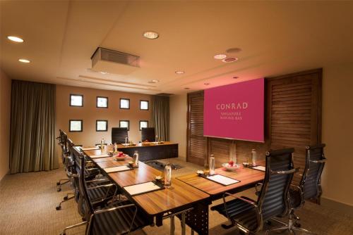 a conference room with a long table and chairs at Conrad Singapore Marina Bay in Singapore