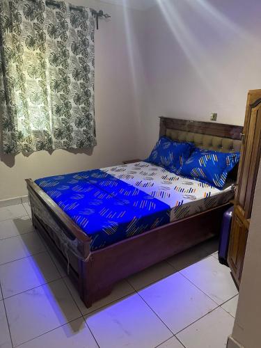 a bedroom with a bed with blue sheets on it at Tapoko residence in Yaoundé