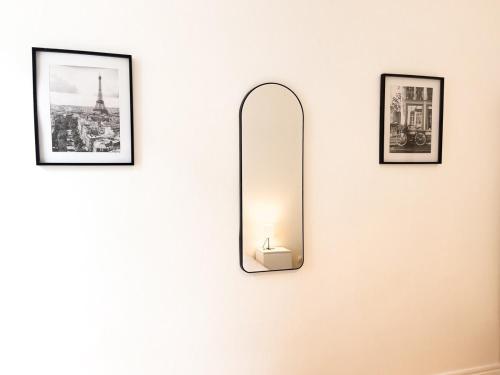 un miroir accroché à un mur avec trois photos dans l'établissement Le Romain - Centre-Ville Gare - Spacieux - Netflix, à Reims
