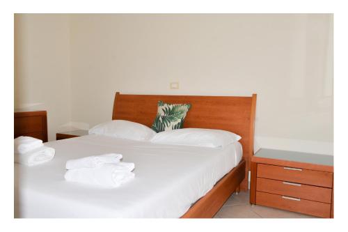 een slaapkamer met een bed met witte lakens en handdoeken bij Fiamme Gialle in Lido di Ostia