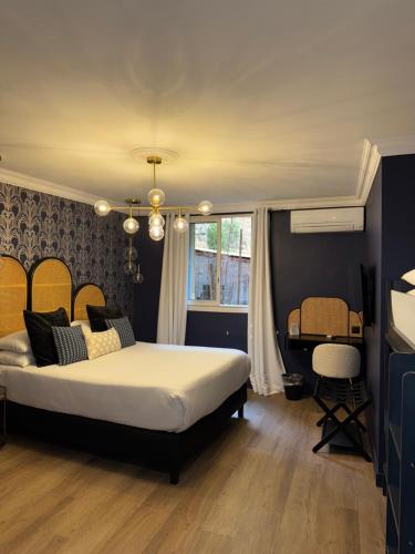 a bedroom with a large bed and a desk at La Caravelle in Aix-en-Provence