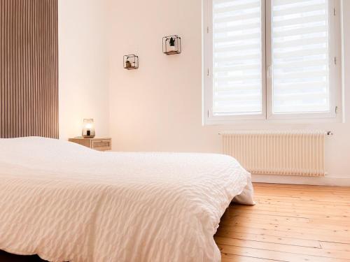 une chambre blanche avec un lit et une fenêtre dans l'établissement Le Romain - Centre-Ville Gare - Spacieux - Netflix, à Reims