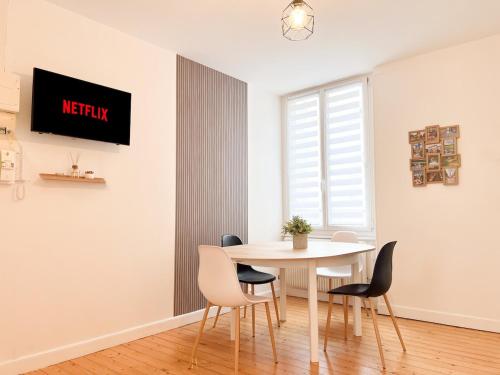 une salle à manger blanche avec une table et des chaises dans l'établissement Le Romain - Centre-Ville Gare - Spacieux - Netflix, à Reims