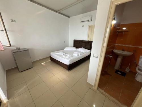 a bedroom with a bed and a sink and a toilet at Blue Marli Rooms in Himare