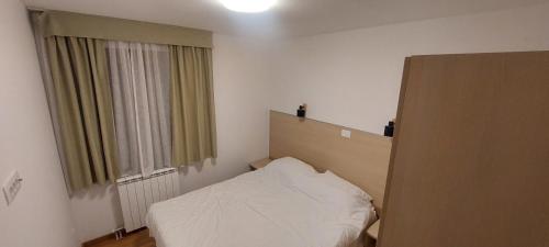 a small bedroom with a bed and a window at Peace & green in Žabljak