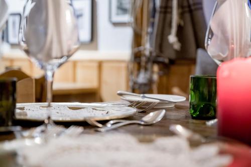 a table with a plate and wine glasses on it at Mondschein Hotel & Chalet Ski-In Ski-Out Luxus am Arlberg in Stuben am Arlberg