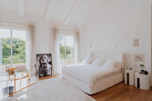 a white bedroom with a large bed and a window at Carmelo Vineyard Villa in Nof Yam