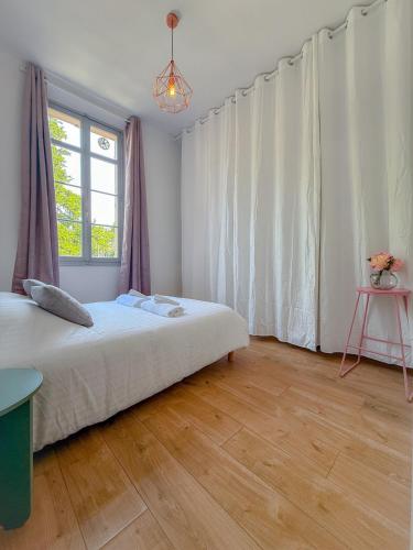 ein Schlafzimmer mit einem großen Bett und einem Fenster in der Unterkunft Le Rosy By ApiRent #Balcon #Wifi #Centre-ville in Cannes