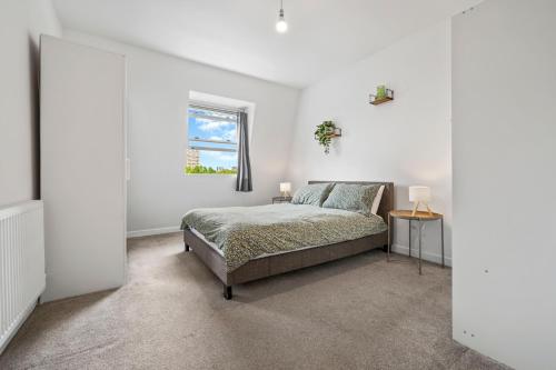 a bedroom with a bed and a window at Prime Location Flats in London