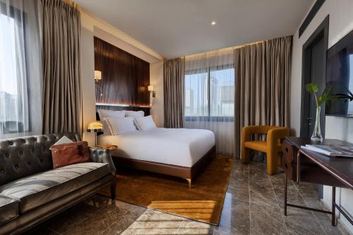 a hotel room with a bed and a couch at Fiori 41-By Adam Hotels in Tel Aviv