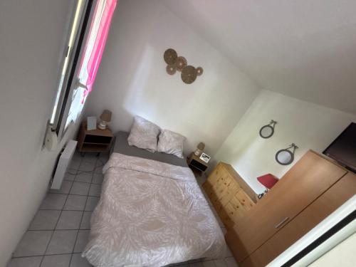 une petite chambre avec un lit et une fenêtre dans l'établissement Appartement Royan, à Vaux-sur-Mer