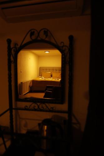 a mirror reflecting a bedroom with a bed in a room at Ayaz Stone House in Goreme