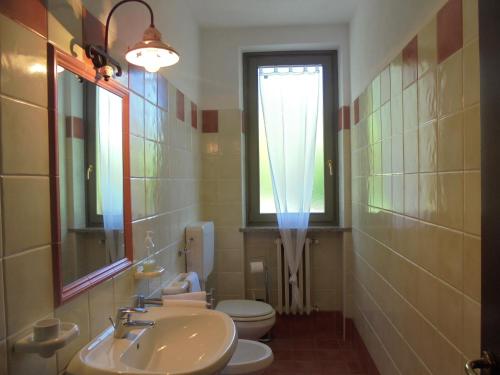 La salle de bains est pourvue d'un lavabo, de toilettes et d'une fenêtre. dans l'établissement Agriturismo La Terrazza sul Bosco, à Barolo
