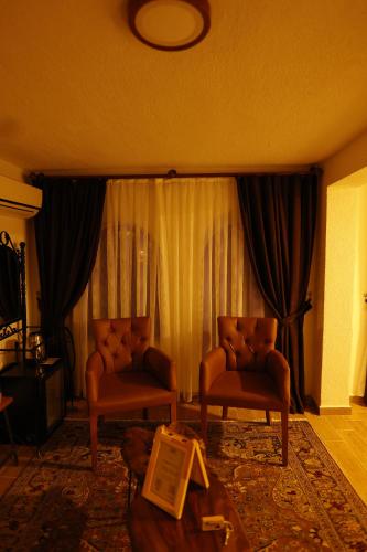 a living room with two chairs and a curtain at Ayaz Stone House in Goreme