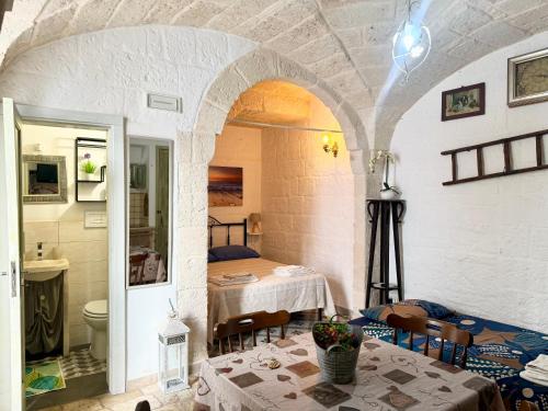 a living room with a table and a bathroom at La Casetta - Typical Guest House in Fasano
