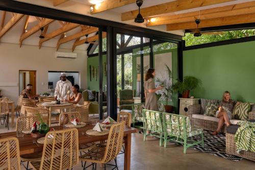 a group of people in a room with tables and chairs at Sashwa River of Stars Plant-Based Wellness Safari Lodge in Hoedspruit