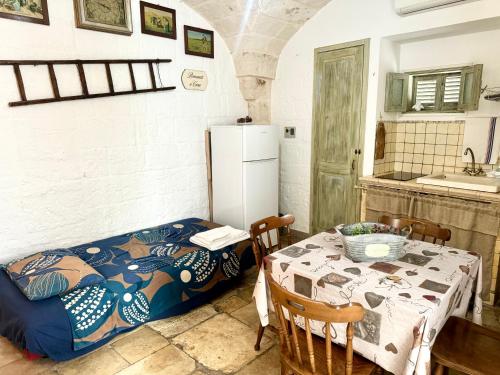 a small kitchen with a table and a refrigerator at La Casetta - Typical Guest House in Fasano