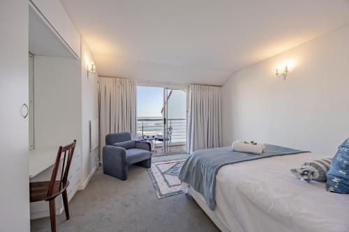 Un dormitorio con una cama, un escritorio y una silla. en Spanish Waterside Villa in Bloubergstrand Cape Town, en Cape Town
