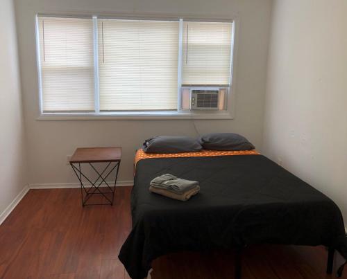 a bedroom with a bed and a window and a table at Large and private apartment in convenient area sleeps up to 5 people comfortably in Elizabeth