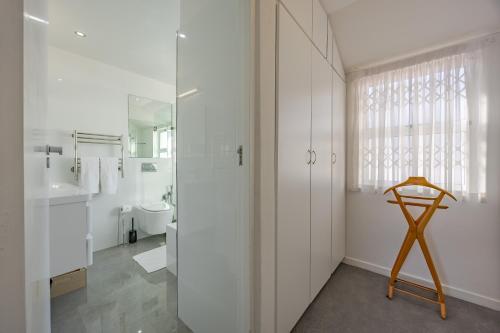 Un baño con lavabo, inodoro y espejo. en Spanish Waterside Villa in Bloubergstrand Cape Town, en Cape Town