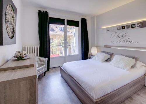 a bedroom with a large bed and a window at Un Appart En Ville "O Fil de l'O" in Annecy