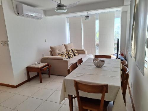 ein Wohnzimmer mit Tisch und Couch in der Unterkunft Paraíso dos Corais in Guarajuba