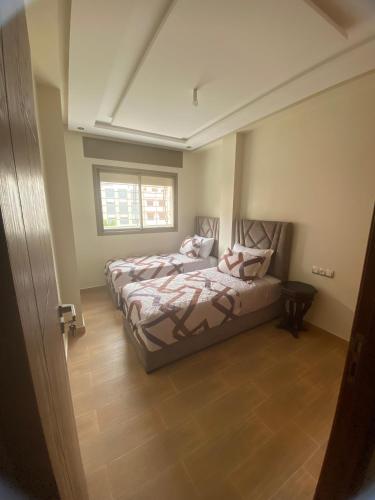 a bedroom with two beds and a window at Appartement spatieux in Tangier