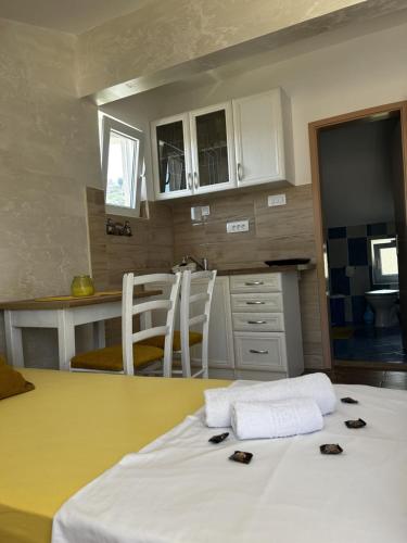 a kitchen with a table with two chairs and a white bed at Fisherman's House Gušti in Kamenari