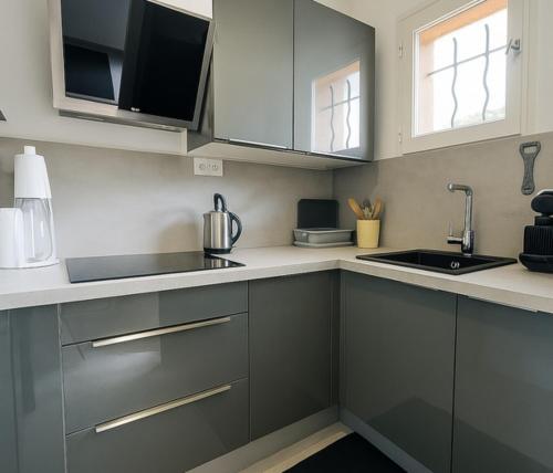 a kitchen with gray cabinets and a sink at Apartment for 6 with garden near beach in Bandol