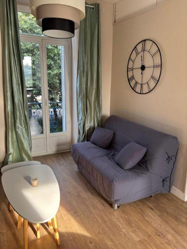 un salon avec un canapé et une horloge au mur dans l'établissement Comfortable apartment in the heart of Vannes, à Vannes
