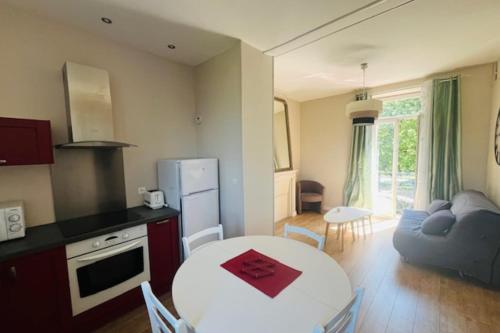 Il dispose d'une cuisine et d'un salon avec une table, une cuisine et un canapé. dans l'établissement Comfortable apartment in the heart of Vannes, à Vannes