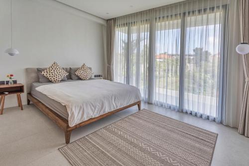 a bedroom with a bed and a large window at Stark villas - modern villa with roof top in Uluwatu
