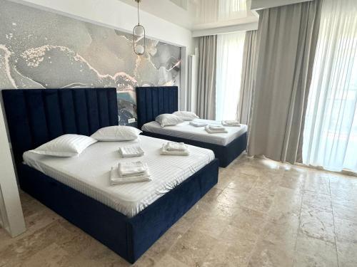 a bedroom with two beds with towels on them at Nord Residence in Eforie Nord