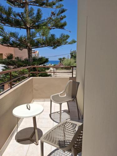 a patio with two chairs and a table and a tree at Lola's Hotel in Plataniás